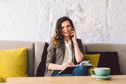 Businesswoman Using Phone Working On Laptop In Coffee Shop. woman calling with cell telephone,
