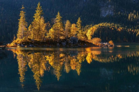 Lake Eibsee with a small island near mountain Zugspitze in south germany in fall