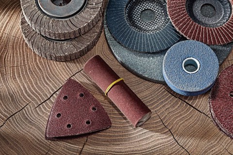 Abrasive Wheels And Papers On Wood Background