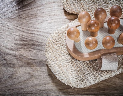 Massager peeling body scrubber on wooden board healthcare concept