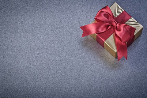 Wrapped present box on grey background holidays concept