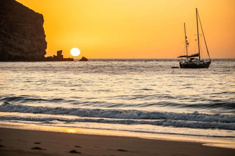 Sunrise during a storm, Calima. A haze-covered horizon turns orange as the sun rises as a ball. A