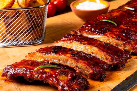 Bbq ersatzribs auf der platte mit grünem salat und weißer soße
