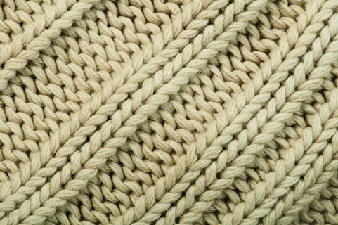 Old knit sweater background. Beige color. Studio shot