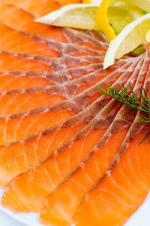 Sliced smoked salmon served with lemon slices