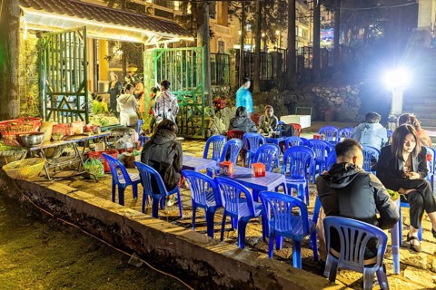 Empty blue chairs and tables under evening lights at a night market, restaurant in the streets of