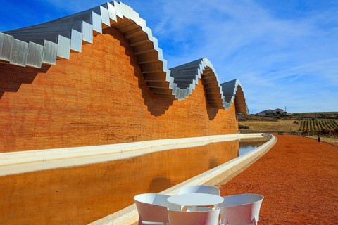Fragment of the facade is reflected in the pool. Winery - bodega Bodegas Ysios. Journey to the warm