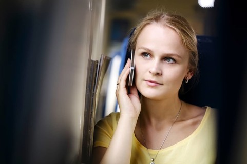 Attractive woman listening to a call on her mobile phone looking into the distance with a