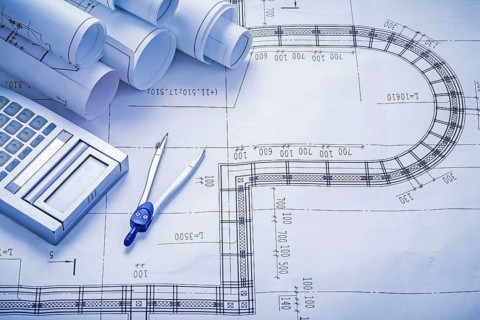 Stack of rolled blueprints calculator compass construction concept