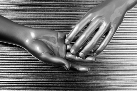 Hands together futuristic robot silver steel over gray background