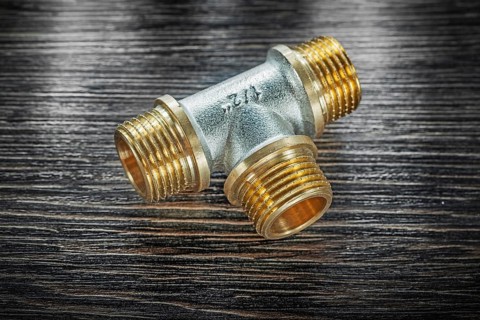 T-tube pipe connector on vintage wooden board