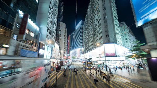 Ride by double-decker tram along the street of night illuminated Hong Kong. View from upper deck