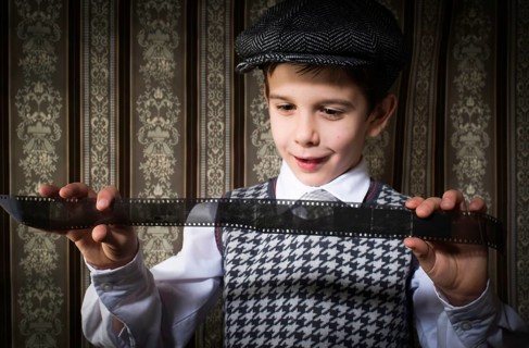 Child considered analog photographic film. Vintage clothes and background