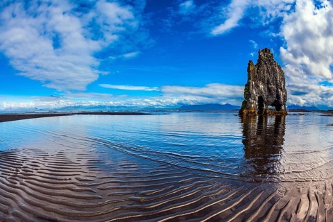 Rock Hvitserkur on the sea beach in the form of a huge elephant. Ocean tide at sunset. The north