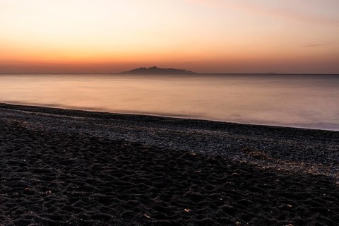 Dawn at sunrise, view from the lava beach near Kamari to the island of Anafi, long exposure, island