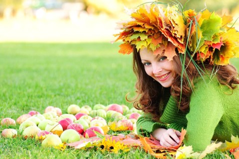 Woman with maple leaves outdoors. Close up face