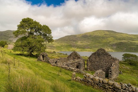 Grey clouds over Llyn Cwmystradllyn with a derelict ruin on the shore, near Penmorfa, Gwynedd,