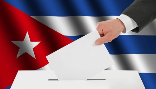The Cuban flag and the hand with the bulletin about the ballot box