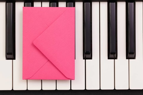 Funny arrangement envelope on the piano keybords - Flat lay image