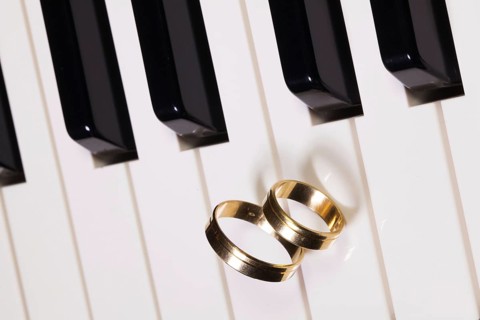 Detail of piano keyboard and wedding rings