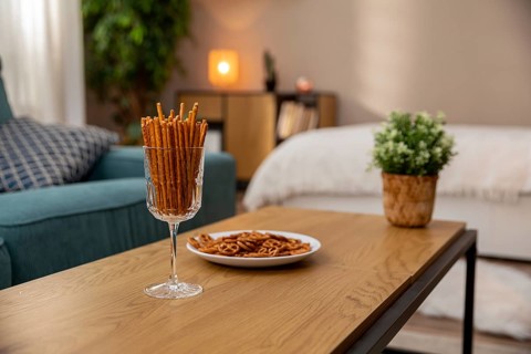 This is a stylish living space that includes pretzel snacks and indoor plants to create a cozy,