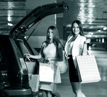 Two young shoppers on a car parking