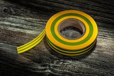 Yellow insulating tape on vintage wooden board