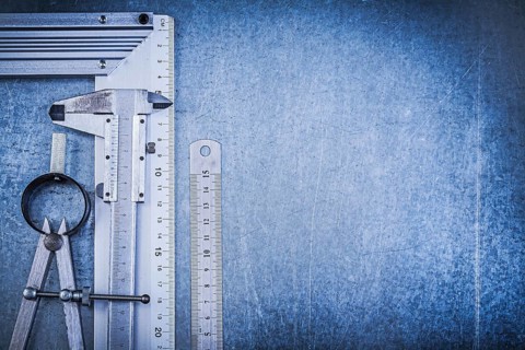 Metal ruler try square slide caliper construction divider on metallic background