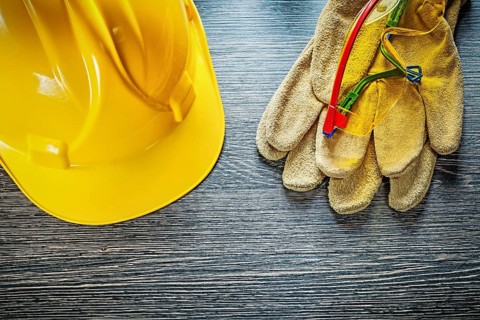 Safety gloves cap goggles on wooden board