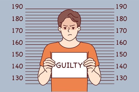 Man criminal with inscription guilty on sign stands near lines for measuring height of arrested