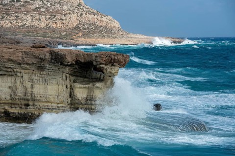 Waves crashing on rocky coast. Windy weather, Powerful sea waves braking on rocks