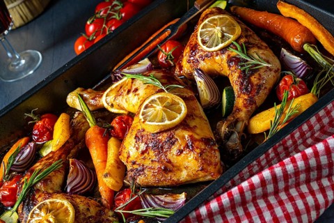 Grilled chicken legs with various vegetables and herbs