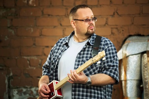 Man playing his three string cigar box guitar