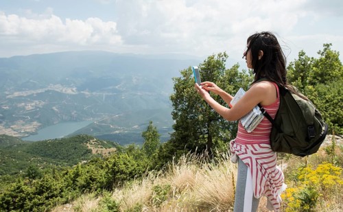 Woman taking pictures with smartphone in the forest