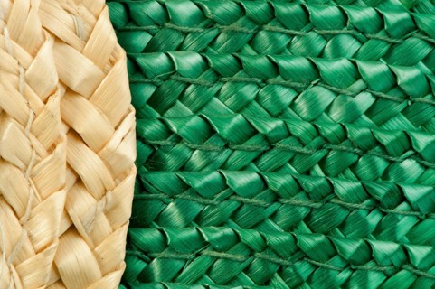 Woven straw natural background. Green and beige colors