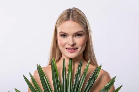 A serene, graceful woman gently cradling a lush aloe vera plant, embodying beauty, wellness, and