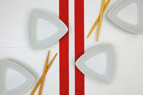 Ceramic bowls and bamboo chopsticks for sushi food with on the white wooden table.Top view. Flat