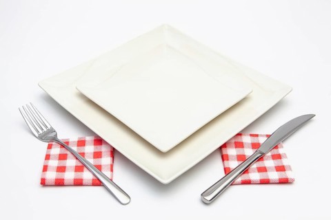 White square plate on the white wooden table.Top view.Flat Lay Image
