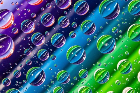 Color pencils under glass with drops of water. Office concept