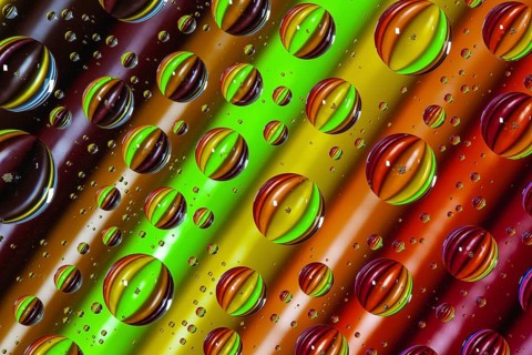Color pencils under glass with drops of water. Office concept