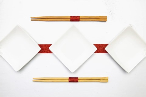 Ceramic bowls and bamboo chopsticks for sushi food with red and white decoration