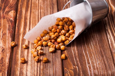 Spicy baked chickpeas in a metal pail on the wooden background