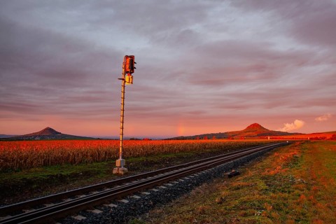 Morning train to the hell. Old Railway tracks running through a field stretch to rural countryside