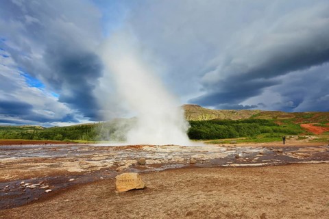 Iceland in the summer. Gushing geyser Strokkur. High column of hot water and steam from the crater