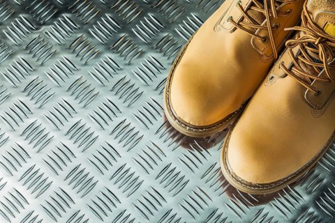 Waterproof safety boots on corrugated metal plate
