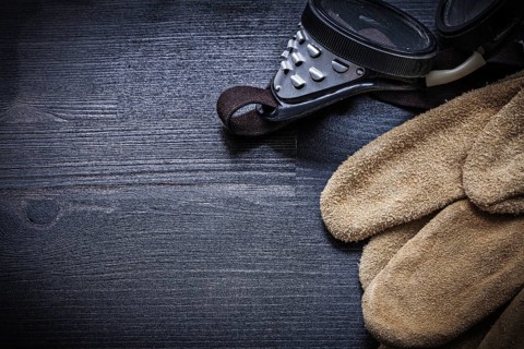Working goggles and protective gloves close up