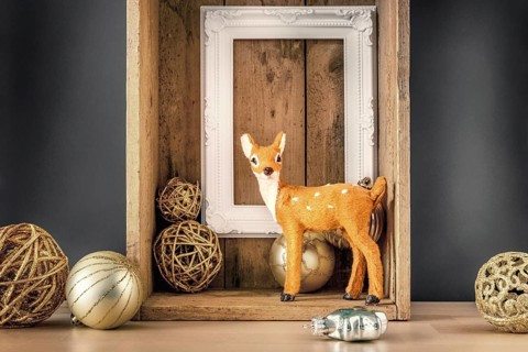 An image of a Christmas decoration wooden box with deer golden balls and a white frame
