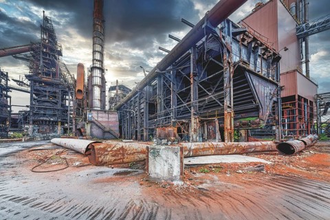 Old abandoned industrial site with rusted structures and empty spaces under a dramatic sky, HF6,