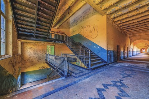 Long, deserted corridor with stairs and graffiti on the walls, Prison H11, Lost Place, Verviers,