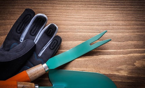 Weeding scoop hand spade protective gloves on wood board